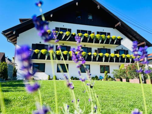 a white building with flowers in front of it at Haus Leitner in Attersee am Attersee
