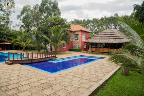 Kabalega Resort - Masindi في Masindi: منزل به مسبح ومبنى