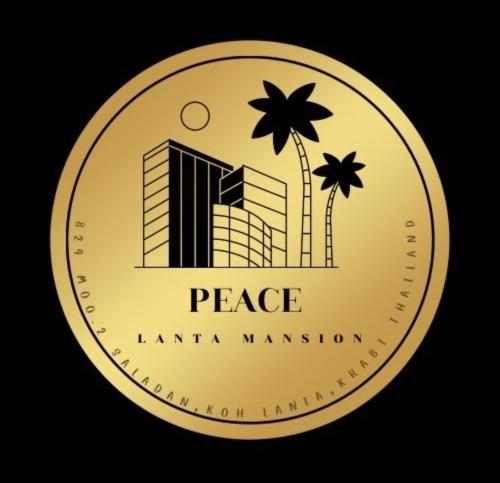 a gold coin with a palm tree and a building at Peace Lanta Mansion in Ko Lanta