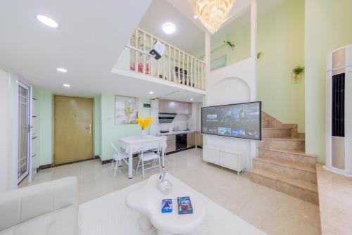 a living room with a tv and a table at Lavendar Duplex Apartment in Guangzhou