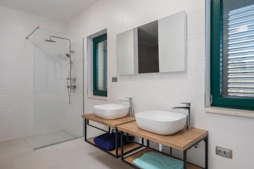 a bathroom with two white sinks and a mirror at Tosic Estate - Villa, Vineyards and Winery in Razvođe