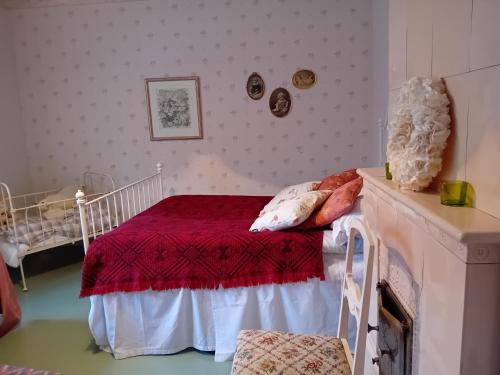Schlafzimmer mit einem Bett mit einer roten Bettdecke in der Unterkunft Bobackan pihatorpan kammarit in Alvettula