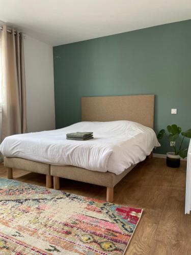 - une chambre avec un lit dans une pièce dotée d'un tapis dans l'établissement Maison 2 chambres Cavaignac, à Calais