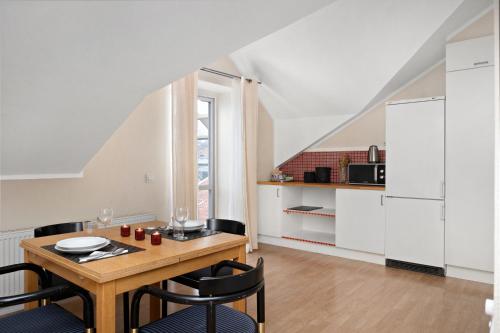 cocina y comedor con mesa y sillas en Stadsparken Apartments, en Helsingborg