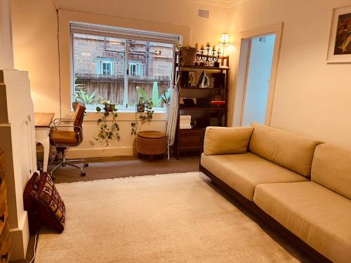 sala de estar con sofá y ventana en Little White Heaven - shared apartment, en Sídney