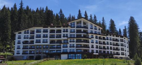 a large white building with trees in the background at Forest Dream Apartment - Elit Pamporovo in Pamporovo