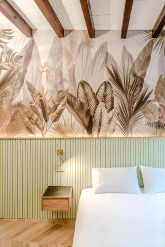 a bedroom with a wall with a mural of leaves at Parco Ducale Design Rooms in Parma