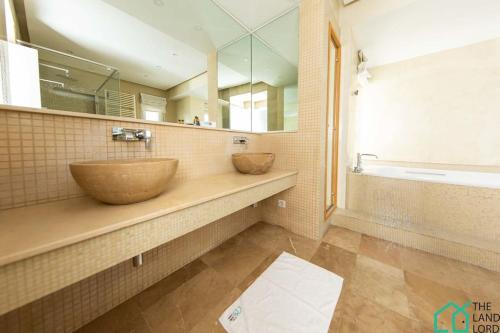 a bathroom with two sinks and a large mirror at Villa Cassel: Villa avec piscine et vue sur le lac in Tunis