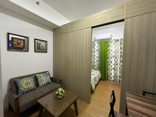 uma sala de estar com um sofá e um quarto em 1bedroom With Balcony Taguig Near Bgc mc kinley em Manila