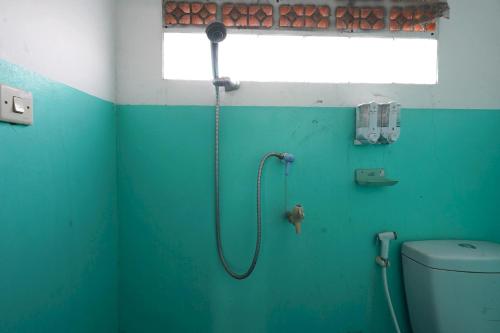 a green bathroom with a shower with a toilet at OYO 93248 Villa Syariah Astuti Lestari in Bandung