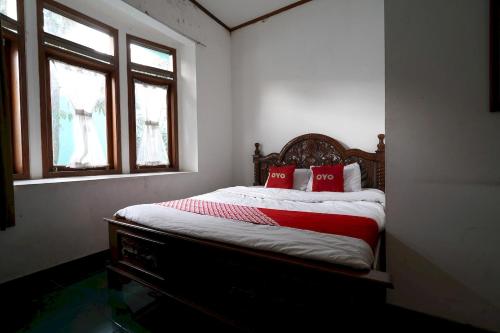 a bedroom with a bed with two red pillows at OYO 93248 Villa Syariah Astuti Lestari in Bandung