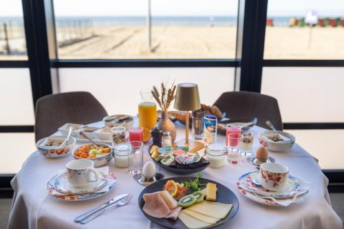 a table with food on it with a view of the beach at Hotel Villa Select in De Panne