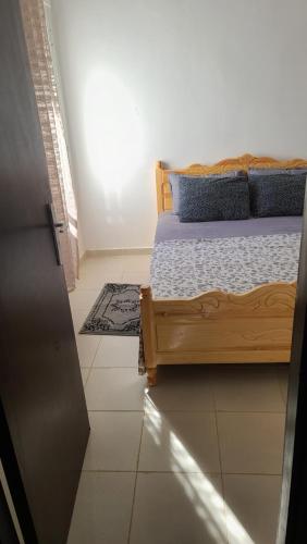 a bedroom with a bed and a tiled floor at Appt al hoceima pour les familles 3ème étage in Al Hoceïma