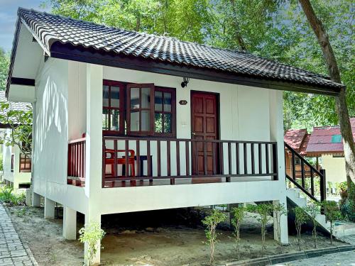 uma pequena casa com varanda e porta vermelha em Vongdeuan Resort em Ko Samet