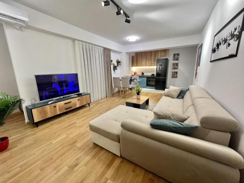 ein Wohnzimmer mit einem Sofa und einem Flachbild-TV in der Unterkunft Corner penthouse apartment in the centar of Skopje in Skopje