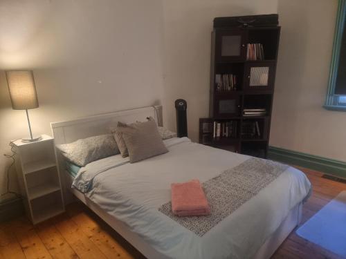 奧克利的住宿－10 Westminster Street，一间卧室配有一张白色大床,上面有橙色毛巾