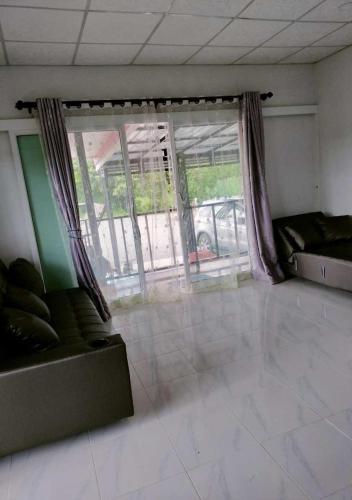 a living room with a couch and a window at Bankhu Homestay บ้านคู่โฮมสเตย์ in Suan Phung