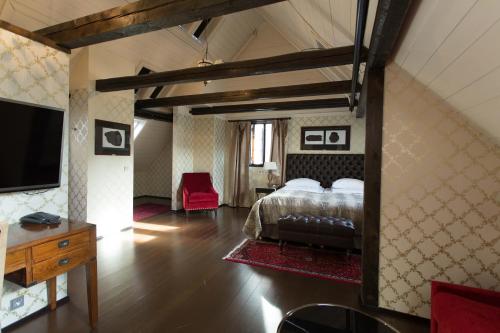 a bedroom with a bed and a tv in a room at Det Hanseatiske Hotel in Bergen