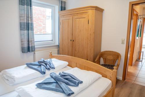 - une chambre avec 2 lits et des serviettes bleues dans l'établissement Ferienwohnung Sonnendeck, à Esens