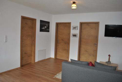 a living room with two doors and a couch at Ferienwohnung Gipfelblick in Weerberg