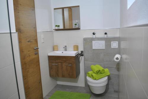 a bathroom with a toilet and a sink with a yellow towel at Ferienwohnung Gipfelblick in Weerberg