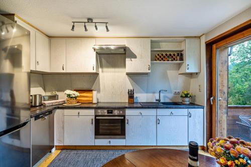 a kitchen with white cabinets and a wooden table at Ferienhaus Cosyhome Vogelsberg in Köddingen