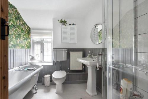 a bathroom with a toilet and a tub and a sink at Character Cottage in Gunnislake in Gunnislake