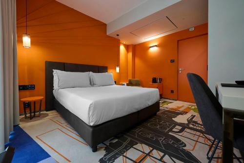 1 dormitorio con 1 cama grande y paredes de color naranja en MyTALE Creative Academy Hotel en Roma