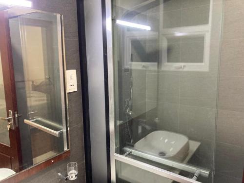uma casa de banho com uma porta de duche em vidro e um lavatório. em Alfred apartments em Colombo