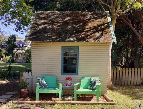 two green chairs sitting outside of a house at 1 Croft Cottage, in Knysna