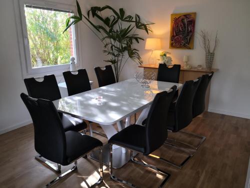 Coolt Oxie في Oxie: غرفة طعام مع طاولة بيضاء وكراسي سوداء