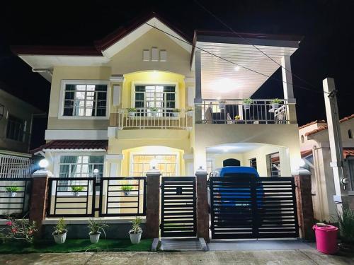 a house with a fence in front of it at night at Hidden Gem: Cebu's Best Escape in Talisay