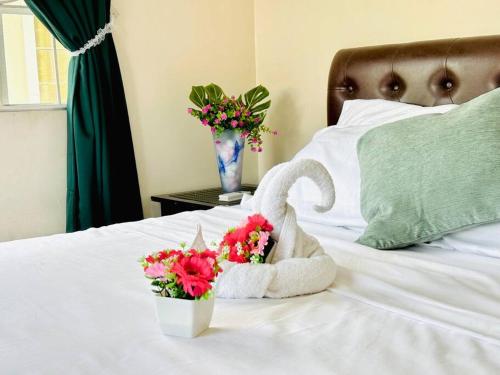 a towel animal sitting on top of a bed with flowers at Hidden Gem: Cebu's Best Escape in Talisay