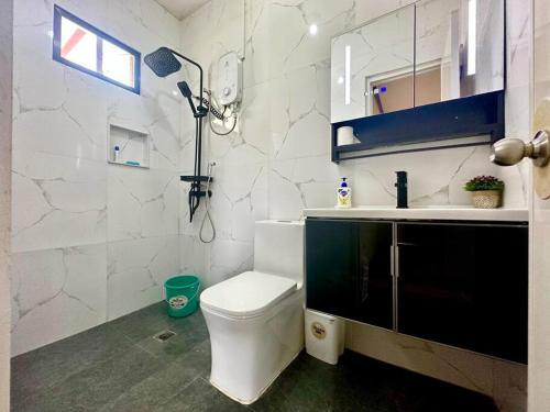 a white bathroom with a toilet and a sink at Hidden Gem: Cebu's Best Escape in Talisay