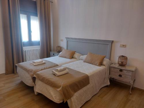 a bedroom with two beds with towels on them at Casa La Plazuelilla in Chinchón