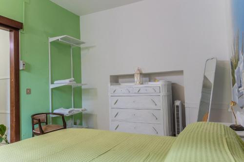 a bedroom with a bed and a dresser and green walls at Casa vacanze Guardea in Guardea