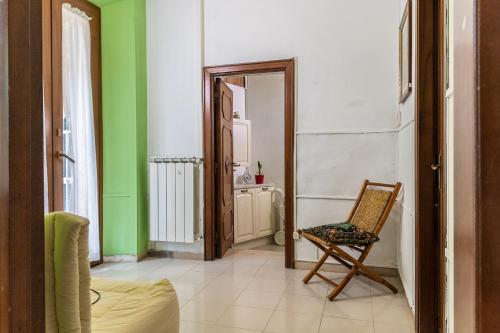 a room with a chair and a bathroom with green walls at Casa vacanze Guardea in Guardea