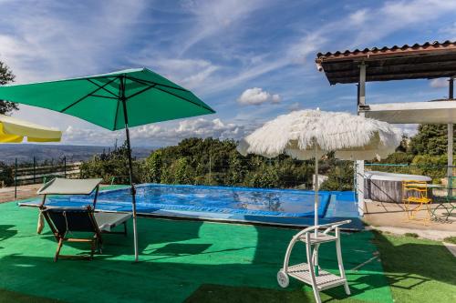 a swimming pool with two chairs and an umbrella at Casa vacanze Guardea in Guardea