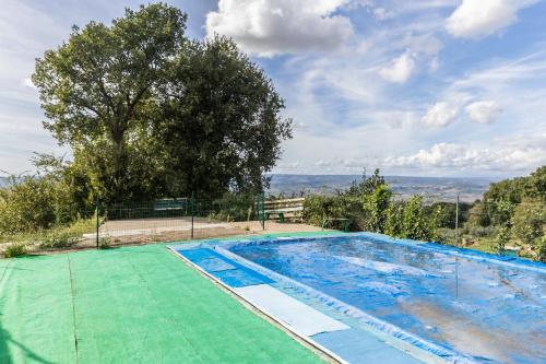a large swimming pool with a tree in the background at Casa vacanze Guardea in Guardea