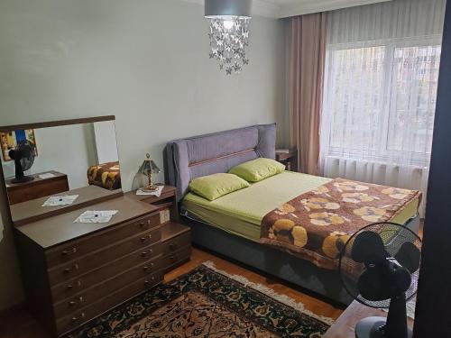 貝利都茲的住宿－Beylikdüzü merkez site içi daire，一间卧室配有一张床、梳妆台和镜子