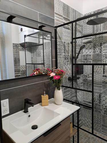 une salle de bain avec un lavabo et un miroir dans l'établissement Le Q'vier, à Montbéliard