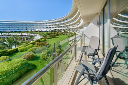 a balcony with chairs and a view of a building at Maxx Royal Belek Golf Resort in Belek