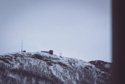 a snow covered hill with a transmitter on top of it at Villa Havblikk Tromsø in Tromsø