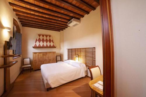 a bedroom with a white bed and a wooden ceiling at Agriturismo Cascina Farisengo in Stagno Lombardo