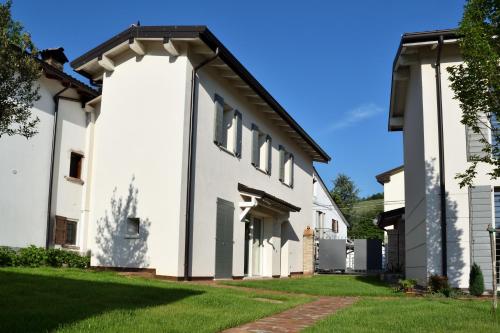 una casa blanca con un arco en B&B Case Bianche, en Maranello