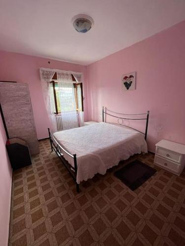 1 dormitorio con 1 cama en una habitación rosa en Affittacamere di Dani, en Spianate