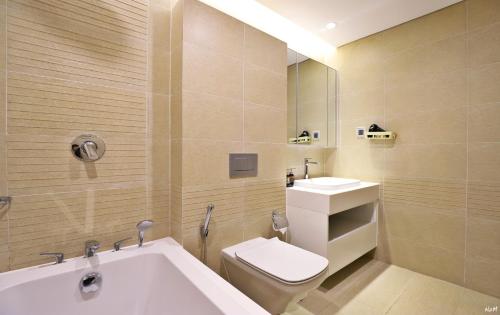 a bathroom with a tub and a toilet and a sink at QMP - Vinhomes Metropolis in Hanoi