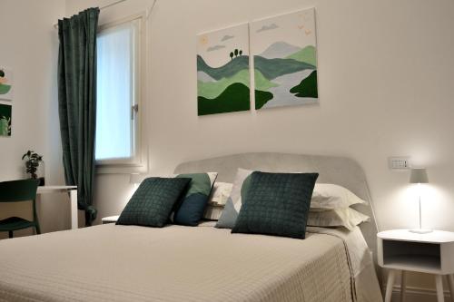 una camera da letto con un letto con cuscini verdi e bianchi di B&B Case Bianche a Maranello