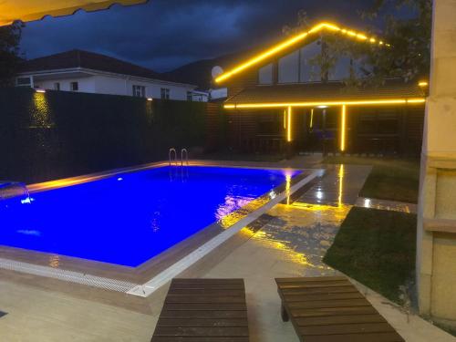 a swimming pool in a backyard at night at sapancafamilyresort Isıtmalı jakuzili havuzu ile Ahşap aile villası in Kartepe