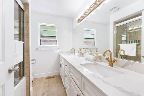 a white bathroom with two sinks and a mirror at A Custom Luxury House Near Metrotown/YVR/SFU in Burnaby